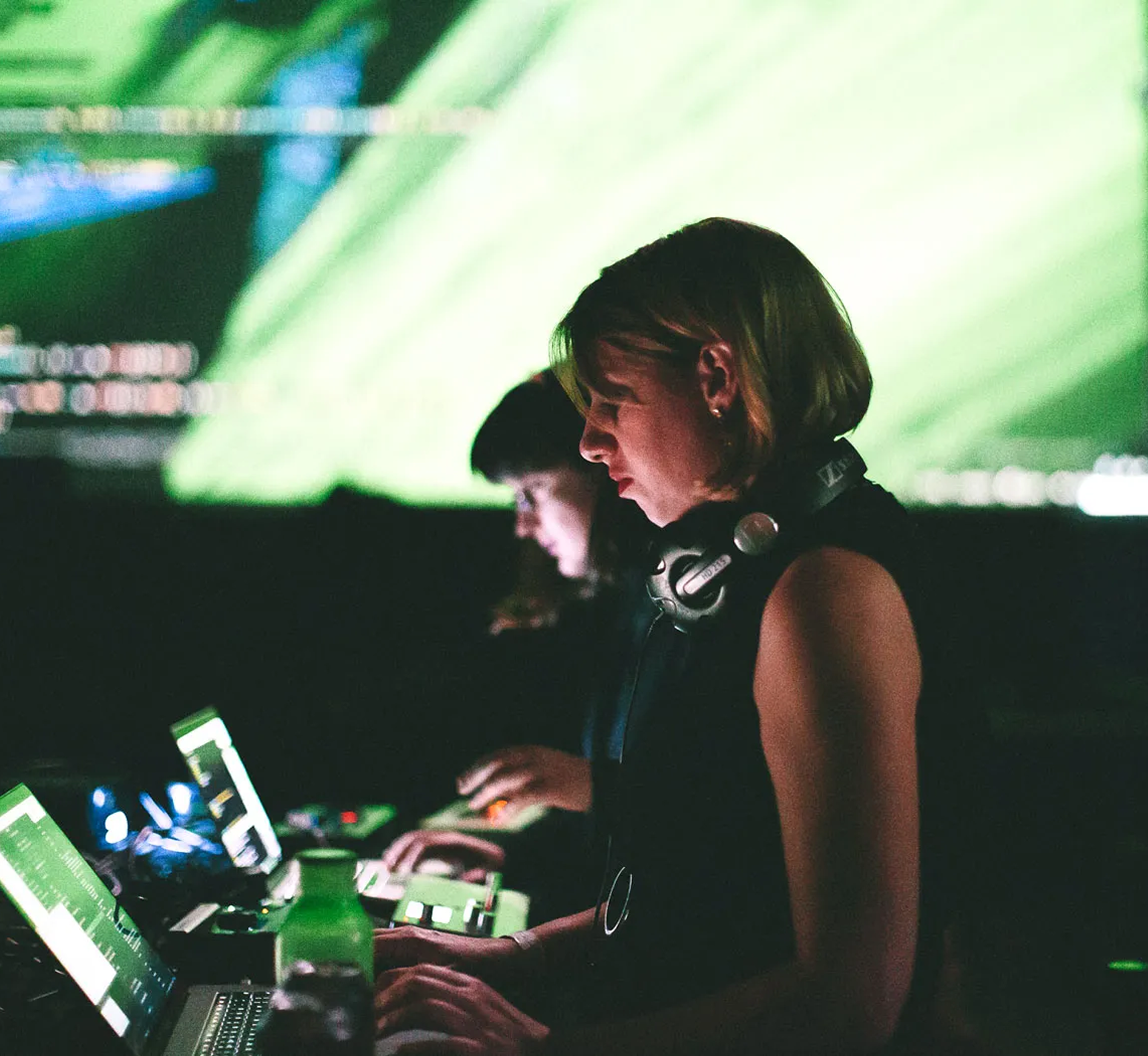 Two DJs playing in front of a giant led screen